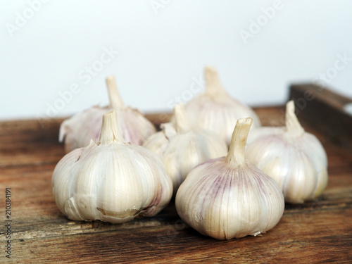 a bunch of garlic on a wooden board close up shot
