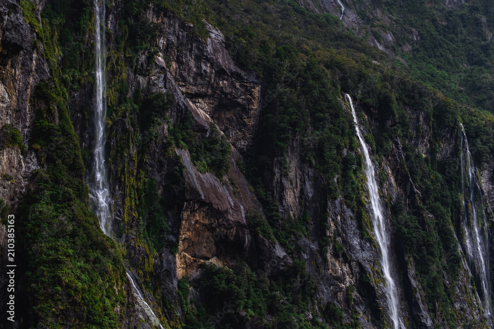 A stunning scene of nature with many waterfalls from the high mountain at Milford Sound, New Zealand. A stunning scene of nature with many waterfalls from the high mountain at Milford Sound, New Zealand.