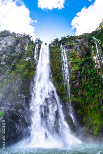 A stunning scene of nature with many waterfalls from the high mountain at Milford Sound, New Zealand.