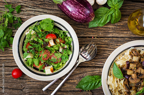 Salad with tomatoes, cheese and cilantro in sweet and sour sauce. Georgian cuisine. Healthy food. Top view. Flat lay