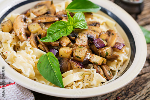 Vegetarian pasta with mushrooms and aubergines, eggplants. Italian food. Vegan meal.