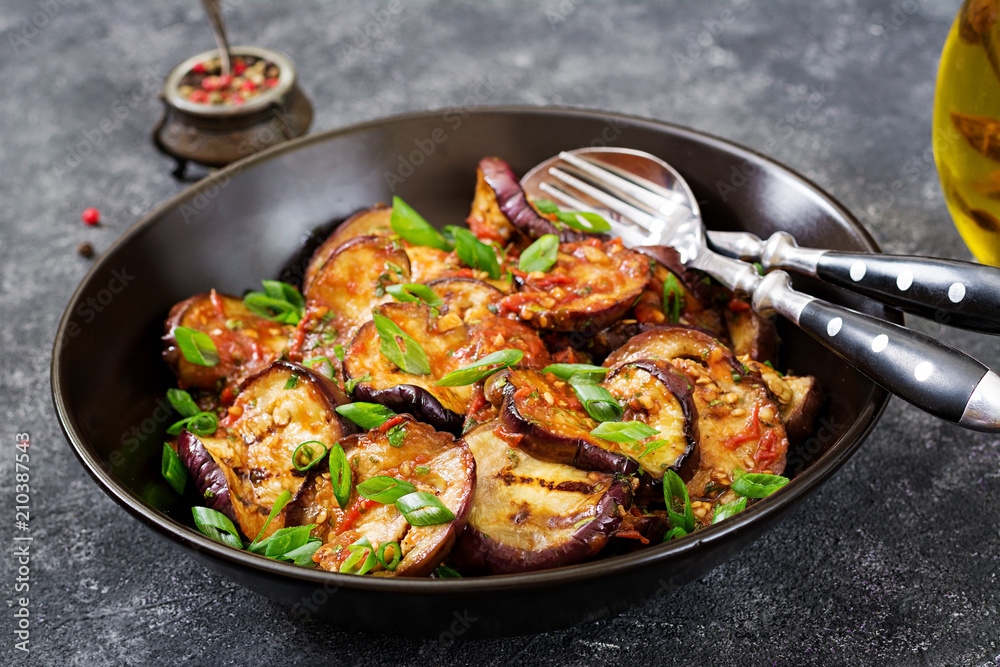 Eggplant grilled with tomato sauce, garlic, cilantro and mint. Vegan food. Grilled aubergine.