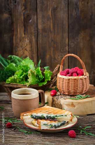 Fototapeta Naklejka Na Ścianę i Meble -  Panini sandwich with cheese and mustard leaves. Morning coffee. Village breakfast