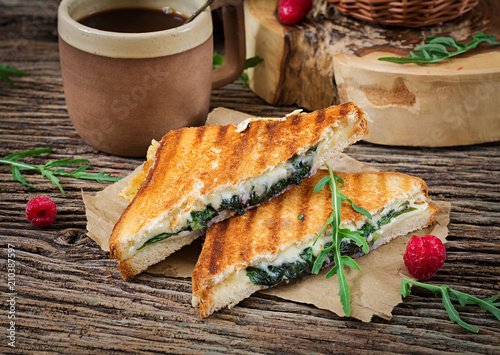 Panini sandwich with cheese and mustard leaves. Morning coffee. Village breakfast