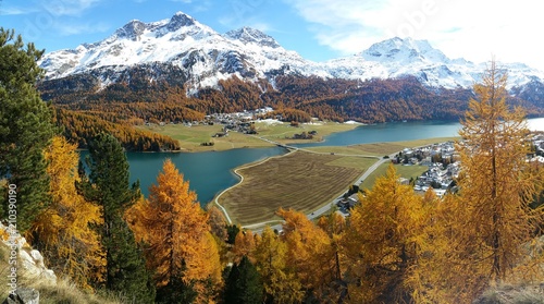 Fotografie The picturesque Swiss town and lake Silva Plana, set amidst the backdrop of the snow clad Swiss alps, as viewed from a height make this Epic Panorama a delight to watch