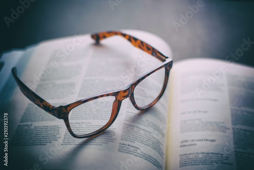 Glasses on text book with warm lighting