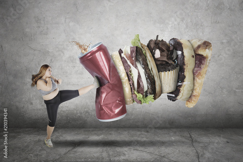 Fat woman kicking unhealthy food and drink