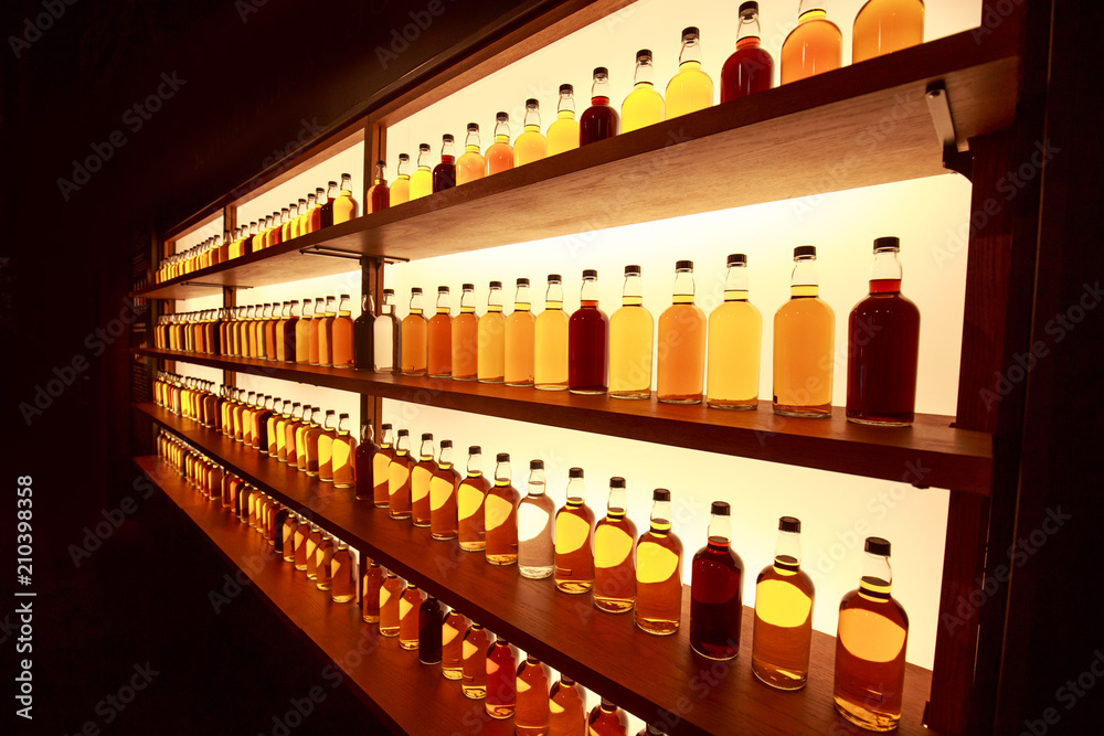 Whiskey bottles in rows on display shelf