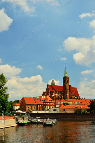 Zabytkowy budynek kościoła nad brzegiem rzeki we Wrocławiu.