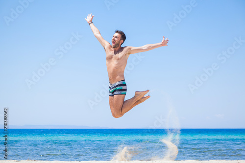 Happy traveler jumping happy at the beach, summer holiday