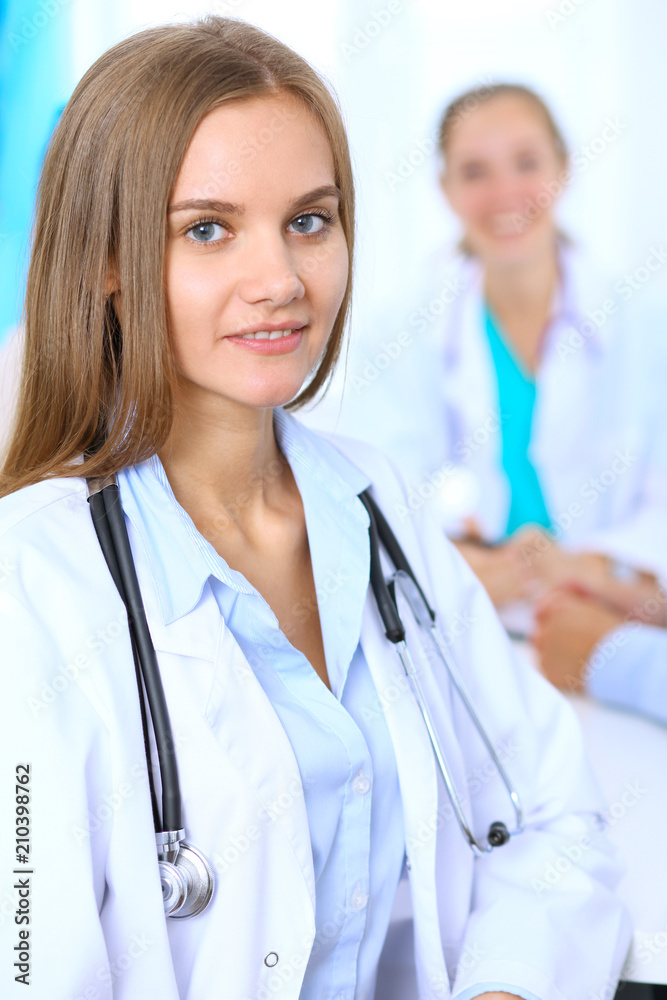 Fototapeta premium Happy doctor woman with medical staff at the background in hospital office