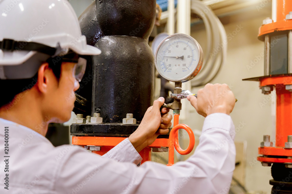 Engineer checking Condenser Water pump and pressure gauge , chiller