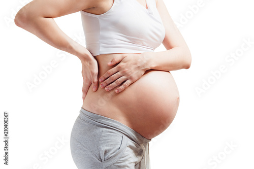 Pregnant young woman with big belly on white background close up. Back pain