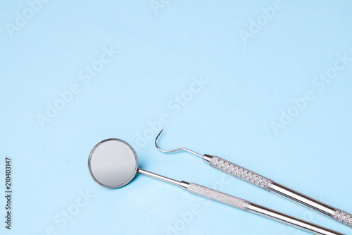 Dental instruments. Dental mirror and probe hook on blue 