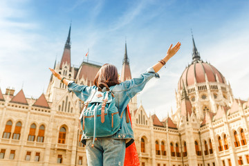 Happy asian casual woman student enjoying great view of the Parliament building in Budapest city, travel in Europe concept