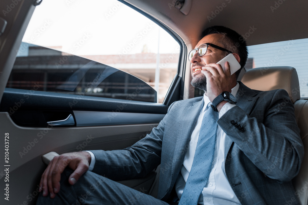 businessman talking on smartphone on backseat in car businessman talking on smartphone on backseat in car