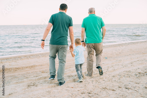 Family, parents, grandparents and grandkids walking on the beach