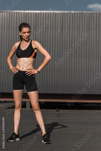 young athletic woman posing with fitness tracker in sportswear