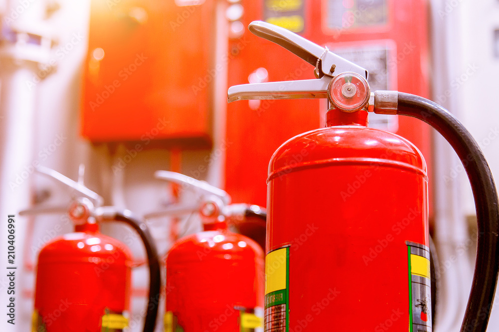 Fototapeta premium Red tank of fire extinguisher Overview of a powerful industrial fire extinguishing system.