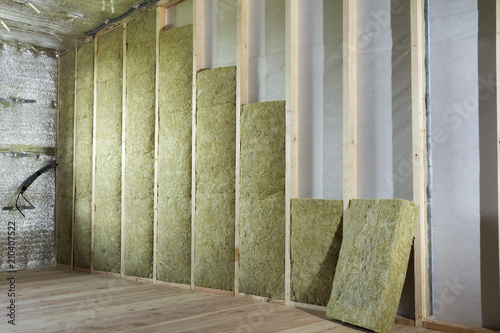 Wooden frame for future walls insulated with rock wool and fiberglass insulation staff for cold barrier. Comfortable warm home, economy, construction and renovation concept. photo