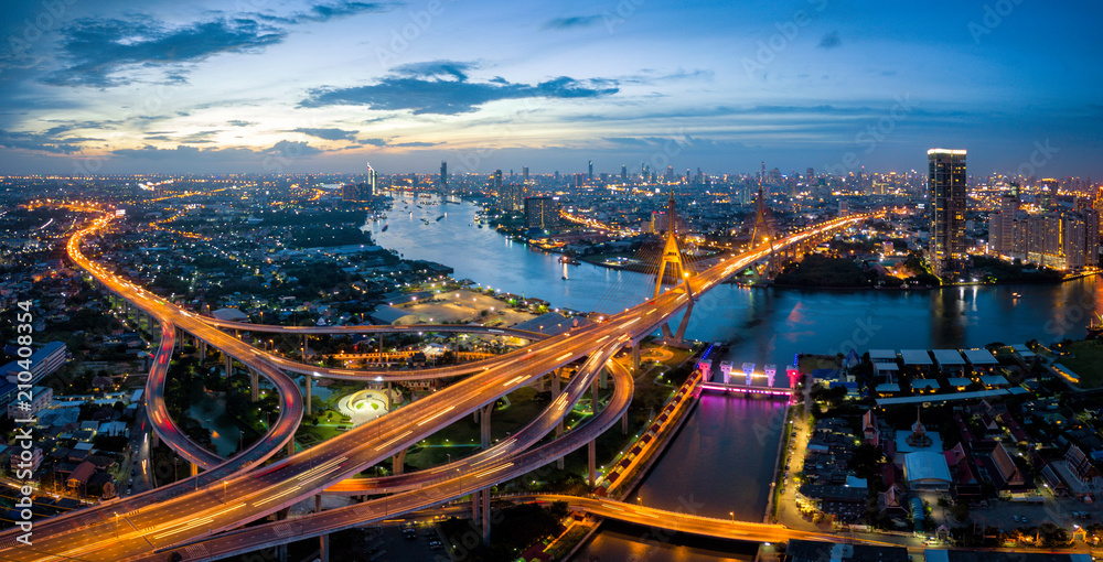 Obraz premium Aerial view of Bhumibol suspension bridge cross over Chao Phraya River in Bangkok city with car on the bridge at sunset sky and clouds in Bangkok Thailand.