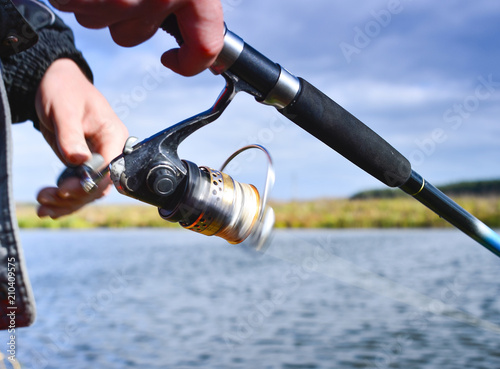 A fisherman catches a fish. Spinning reel closeup. Shallow depth of field on the spool of fishing line