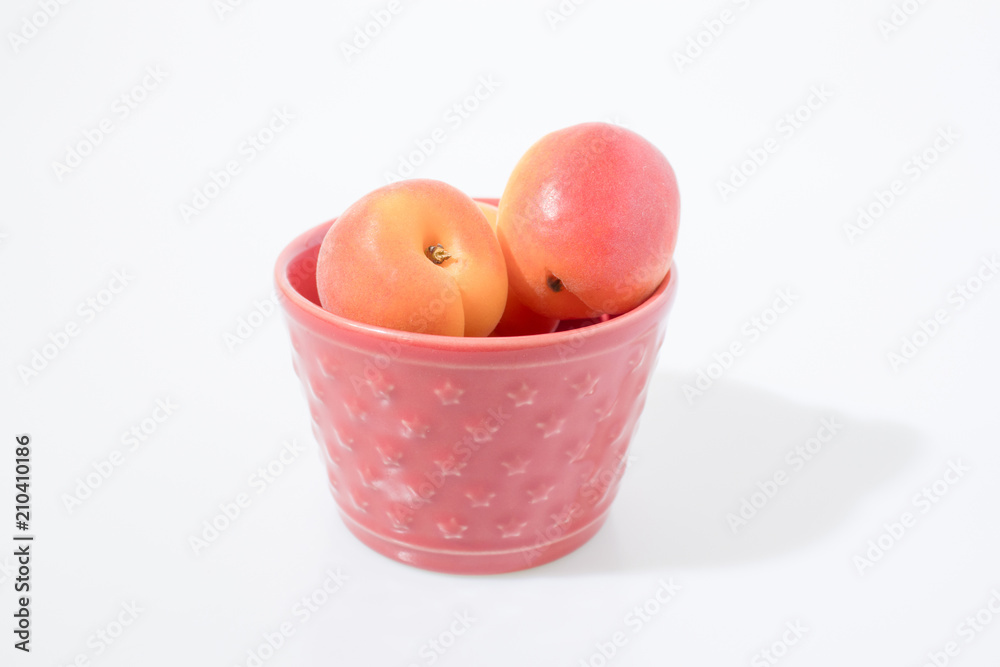 Fruit composition, apricots in a container isolated in a white background Fruit composition, apricots in a container isolated in a white background
