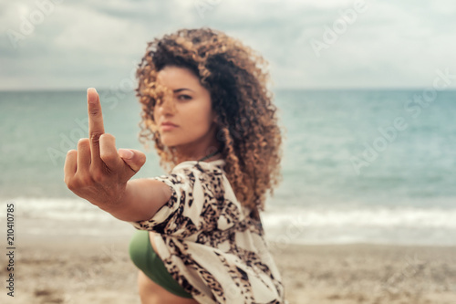 Beautiful and angry woman portrait giving the finger photo