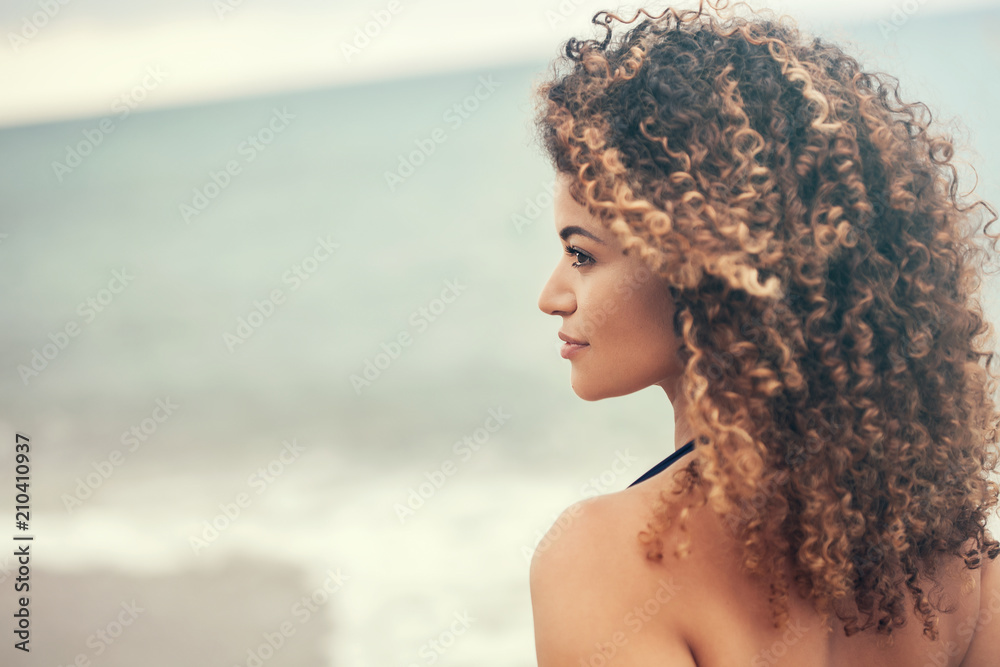 Lovely woman portrait on the beach looking aside and smiling - obrazy, fototapety, plakaty 