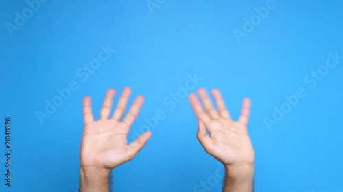Two male screen on a blue background waiving at the camera. Close up footage