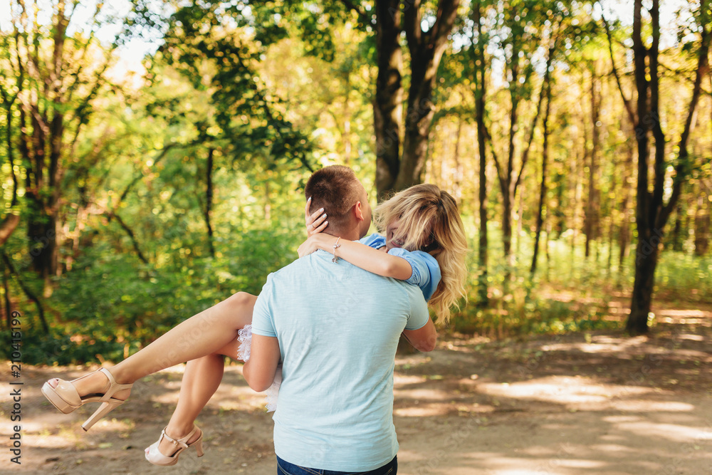 Young man holding girlfriend in his arms outdoors Young man holding girlfriend in his arms outdoors