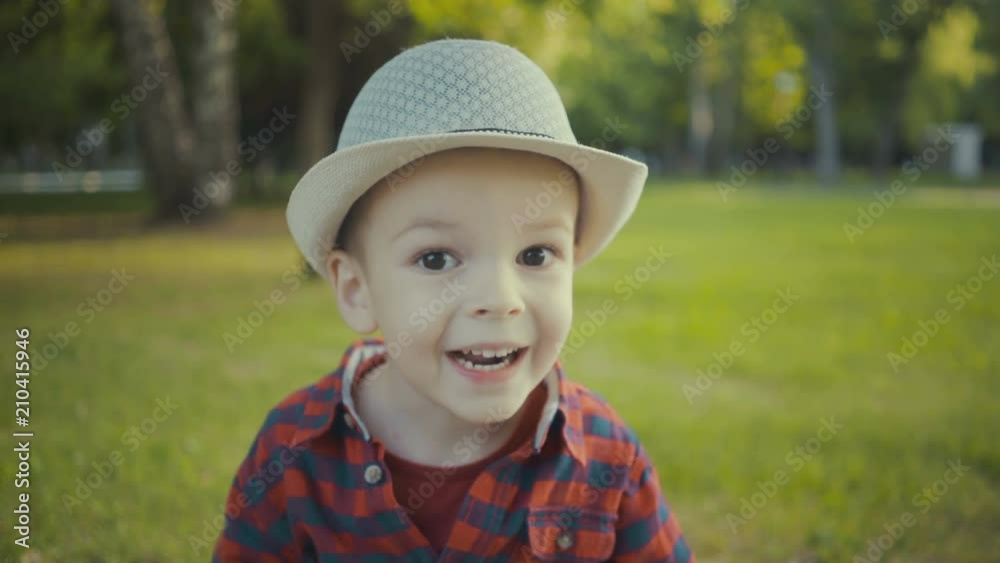 portrait of a boy of two years in a hat and shirt in the park. portrait of a boy of two years in a hat and shirt in the park.
