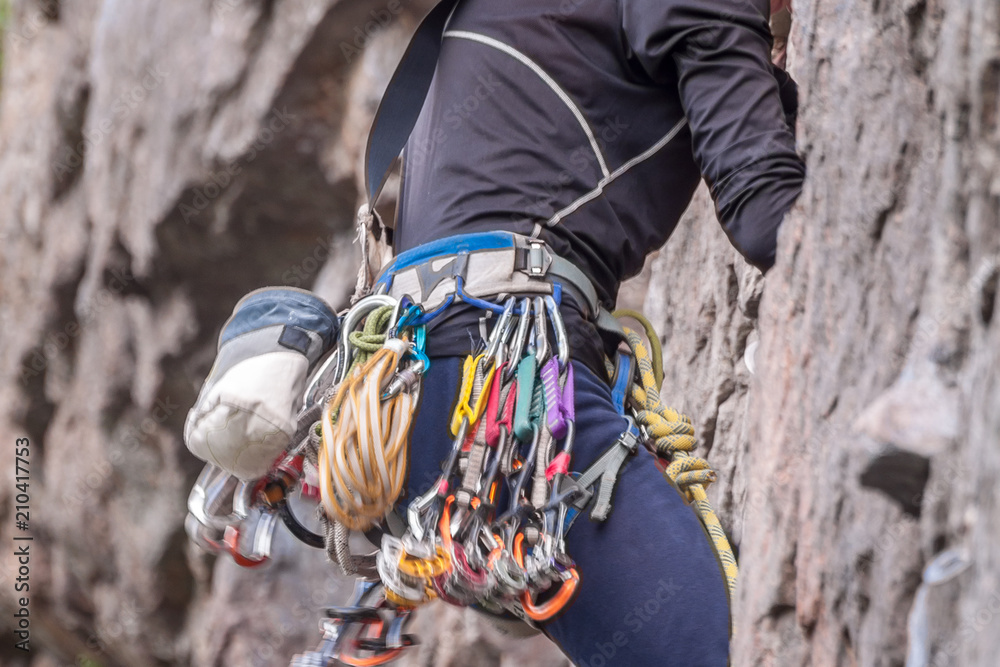 Obraz premium Rock climbing. Climber close-up. Extreme sport. A young climber climbs a vertical granite rock.