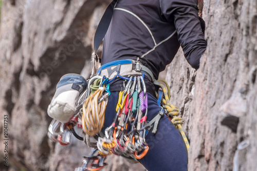 Rock climbing. Climber close-up. Extreme sport. A young climber climbs a vertical granite rock.
