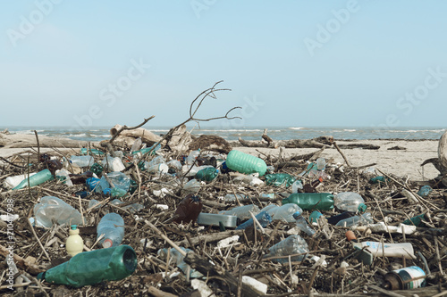 Spilled garbage on the beach of the big city. Empty used dirty plastic bottles. Dirty sea sandy shore of the Black Sea. Environmental pollution. Ecological problem