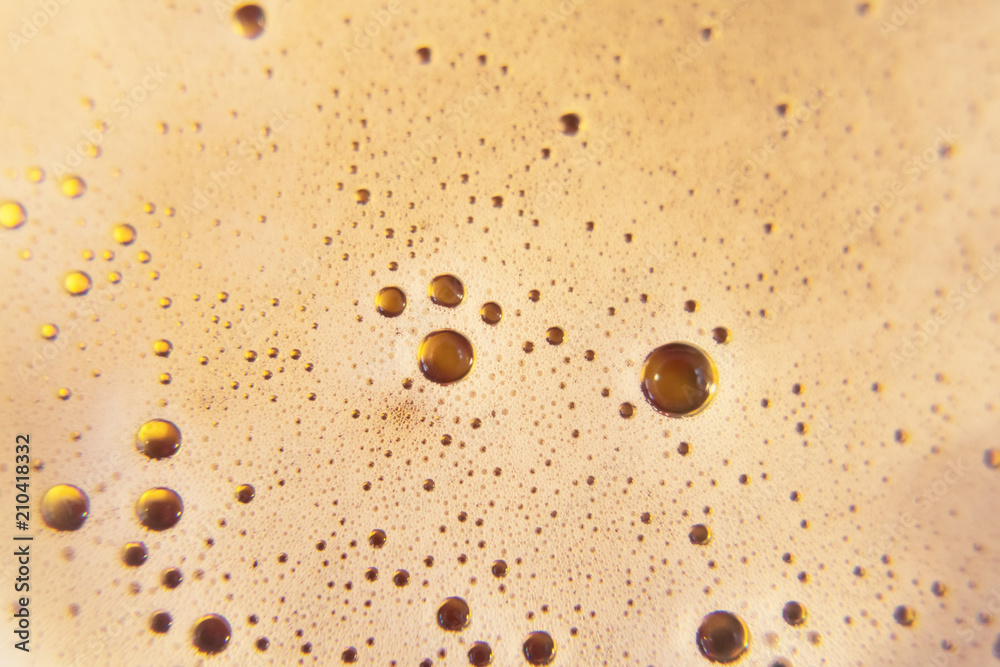 The foam of tasty fresh beer poured in a glass, shot from above.
The foam of tasty fresh beer poured in a glass, shot from above.
