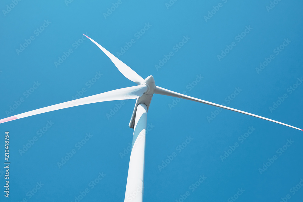 Alternative energy sources. Large rotating wind turbine blades against the blue sky on a wind farm close-up. Slow motion Alternative energy sources. Large rotating wind turbine blades against the blue sky on a wind farm close-up. Slow motion
