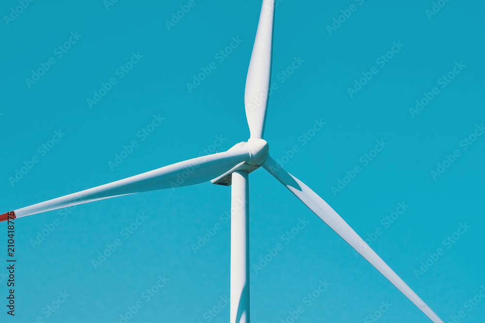 Alternative energy sources. Large rotating wind turbine blades against the blue sky on a wind farm close-up. Slow motion Alternative energy sources. Large rotating wind turbine blades against the blue sky on a wind farm close-up. Slow motion