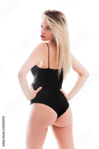 Blonde woman back portrait looking over shoulder with arms akimbo, vertical