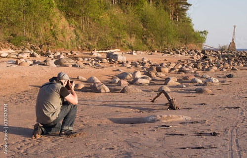 Photographer making shot on the seaside with old lighthouse