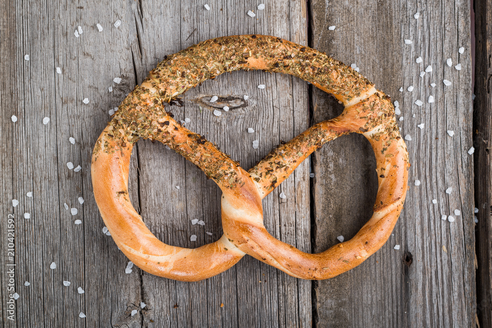 Pretzels on wooden board on rustic background. Spices, olive grass Pretzels on wooden board on rustic background. Spices, olive grass