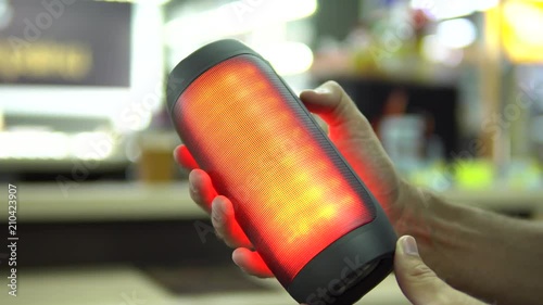 Portable speaker glows in hand.