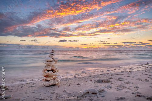 Rock sculpture on a beach in front of the sunset in Australia