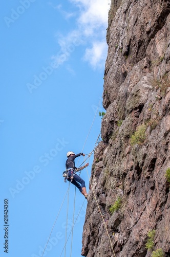 Rock climbing. A young climber climbs a vertical granite rock. Extreme sport.