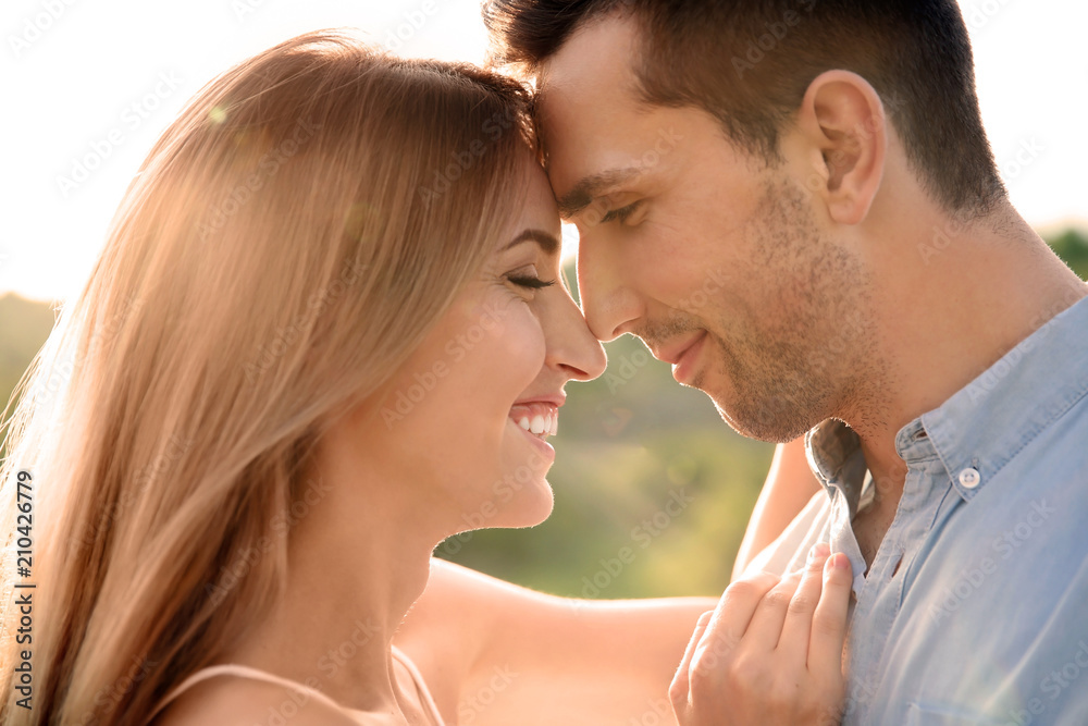 Cute young couple in love posing outdoors on sunny day Cute young couple in love posing outdoors on sunny day