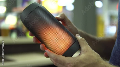 Portable speaker glows in hand.