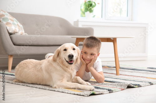 Cute little child with his pet on floor at home