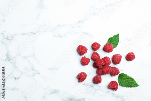 Ripe aromatic raspberries on marble table, top view