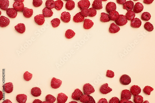 Flat lay composition with ripe aromatic raspberries on color background