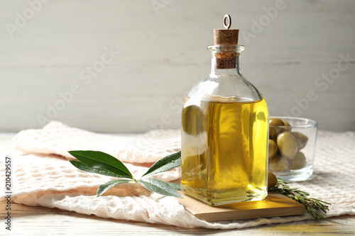 Bottle with fresh olive oil on table